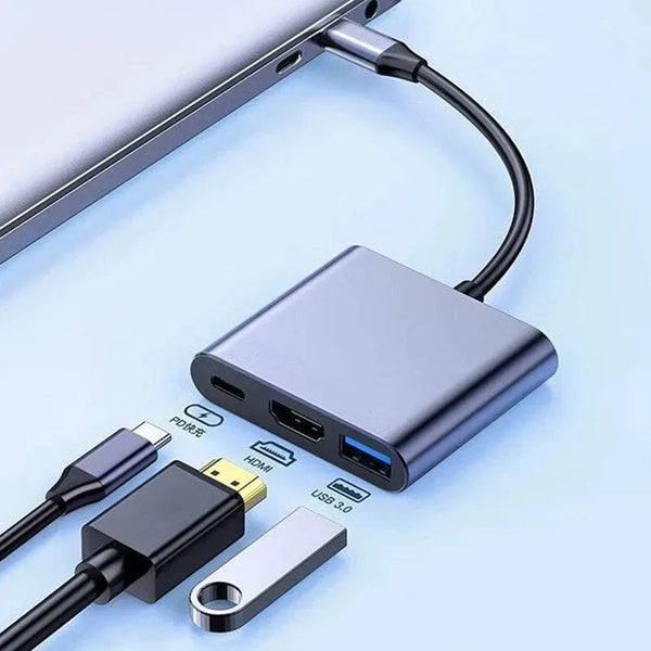 A silver USB-C hub with HDMI and power delivery ports connected to a laptop cable.
