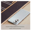 Silver smartphone placed on a dark mat with light wood background.