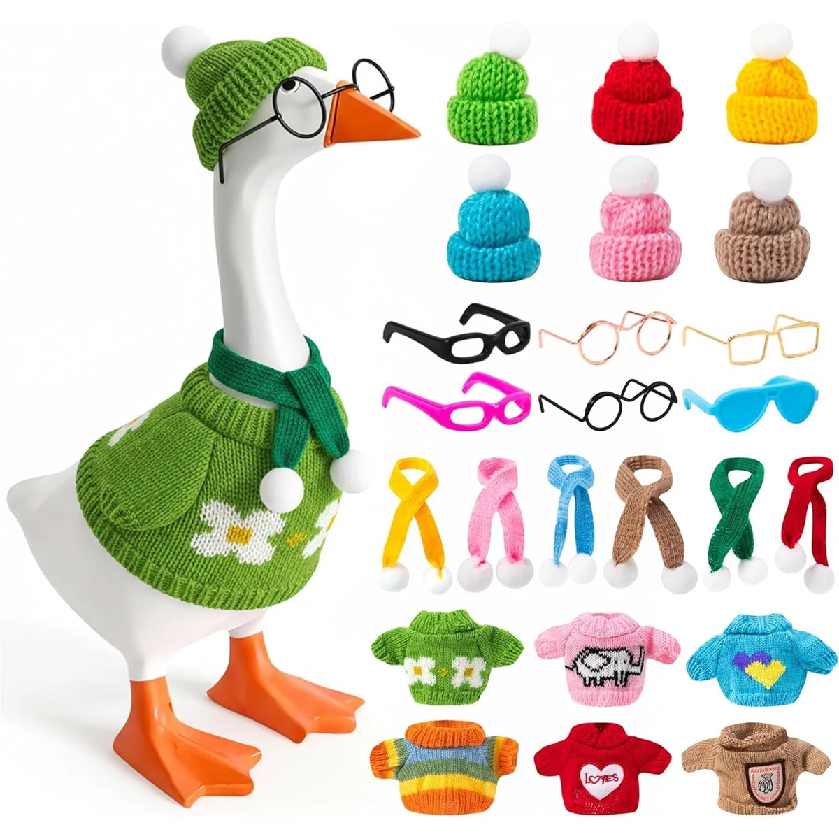 A white goose statue wearing a knitted green sweater and matching hat, with various knitted accessories displayed below.