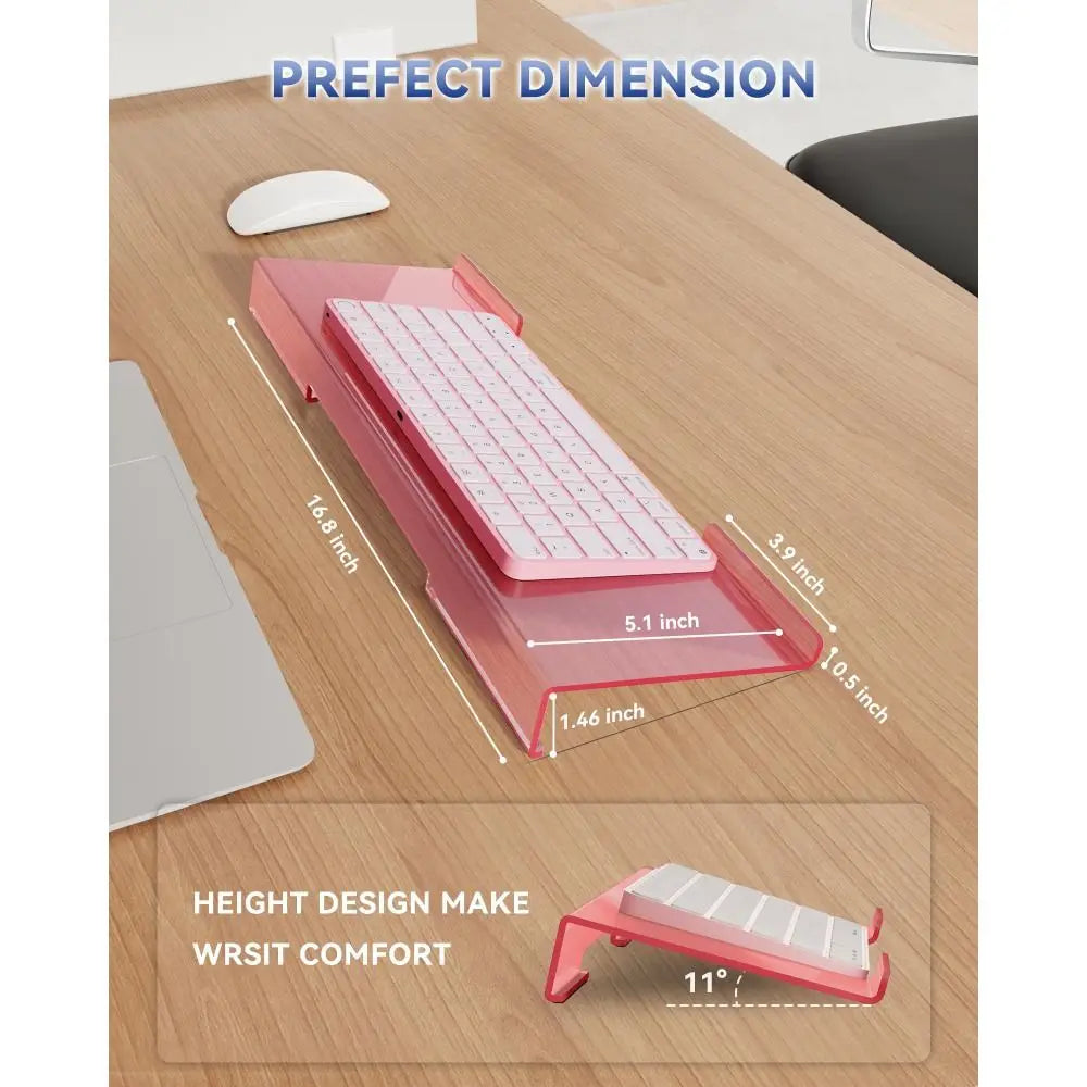 Pink acrylic ergonomic keyboard riser shown on a wooden desk with dimension measurements.