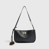 A black leather tote bag with a gold-toned metal buckle and long strap.