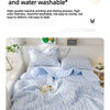A light blue floral quilted blanket is displayed on a bed, showing its soft texture and pattern.
