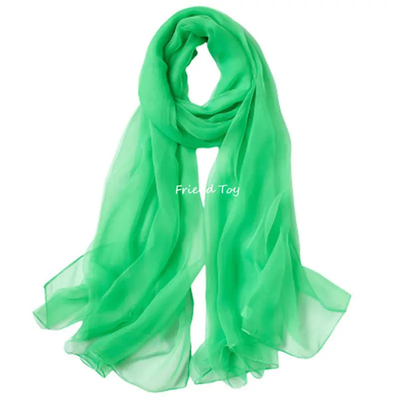 A bright green silk scarf or fabric displayed for imaginative play.