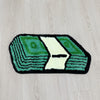 A rectangular mat featuring a green dollar bill design with a white cutout, used for bathroom or entryway