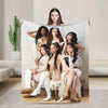 A group of five women posing with a white microfiber fleece throw blanket.