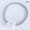 A silver-toned magnetic curtain clip made of twisted wire, shown against a white background.