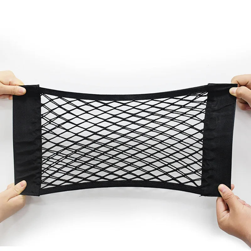 Black elastic mesh car seat back organizer being held by hands.