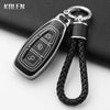 A black silicone car key fob cover with a silver clip and black braided lanyard.