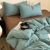 A teal and beige striped duvet cover set with matching pillowcases on a bed.