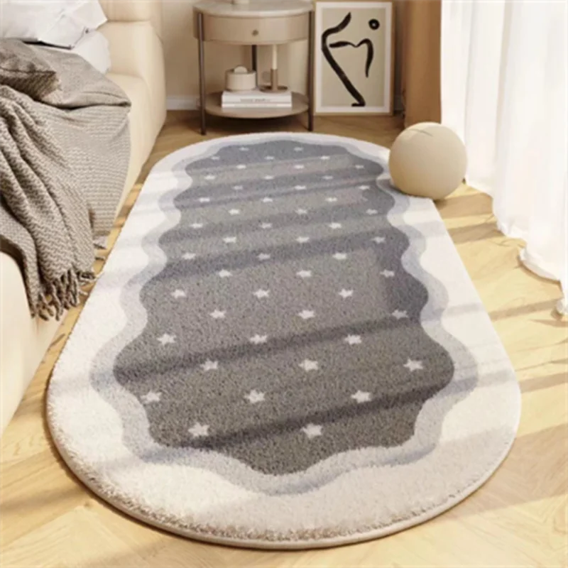 A plush gray and white decorative area rug with a scalloped edge and subtle star pattern on a light wooden floor.