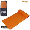 Orange microfiber sports towel rolled up, showing its texture and absorbent material.