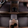 Interior view of a car featuring brown leather floor mats and a center console with controls.