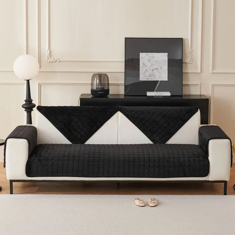 A modern sofa with black and white patterned cushion covers sits in a light-colored room.