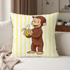 A yellow and white striped pillow featuring a cartoon monkey character, Curious George.