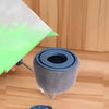 A close-up view of a gray self-priming paint roller head and a green paint roller, with a hand holding the green roller.