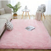 Pinker Plüschteppich mit langem Flor auf hellem Holzfußboden in einem hellen Wohnzimmer