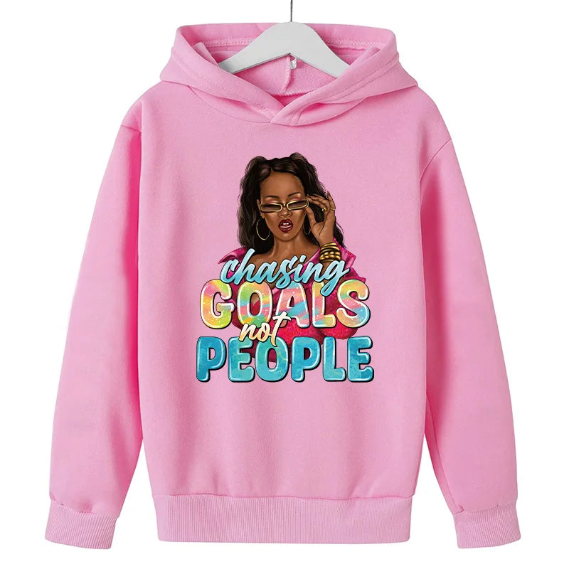 Pink hoodie featuring a graphic of a woman with glasses and hair, with the text Chasing Goals not People.
