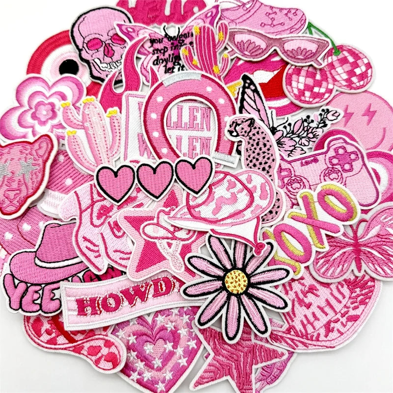 Assorted pink embroidered iron-on patches featuring skulls, flowers, and decorative elements for DIY projects