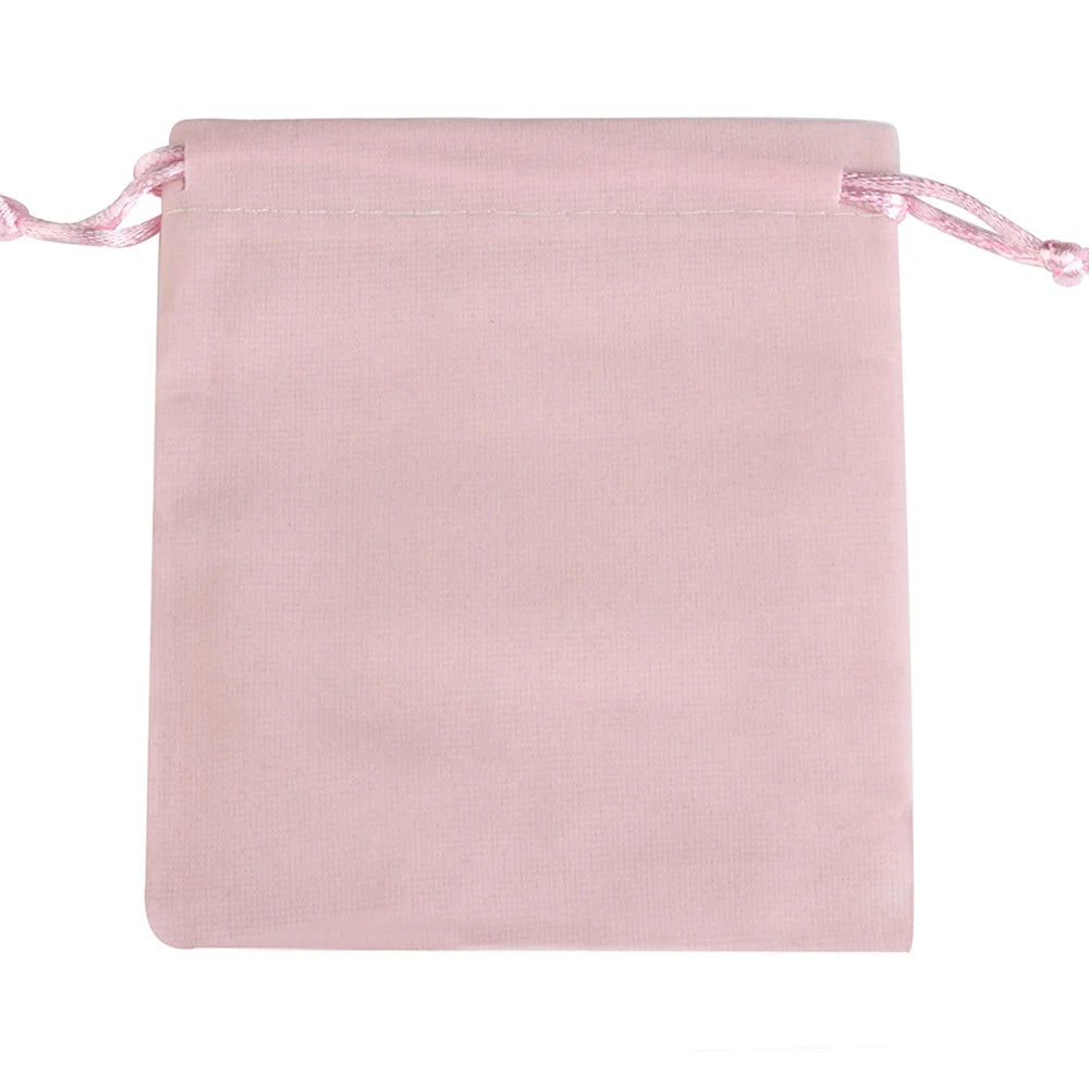 A soft pink velvet drawstring jewelry pouch with pink ties.