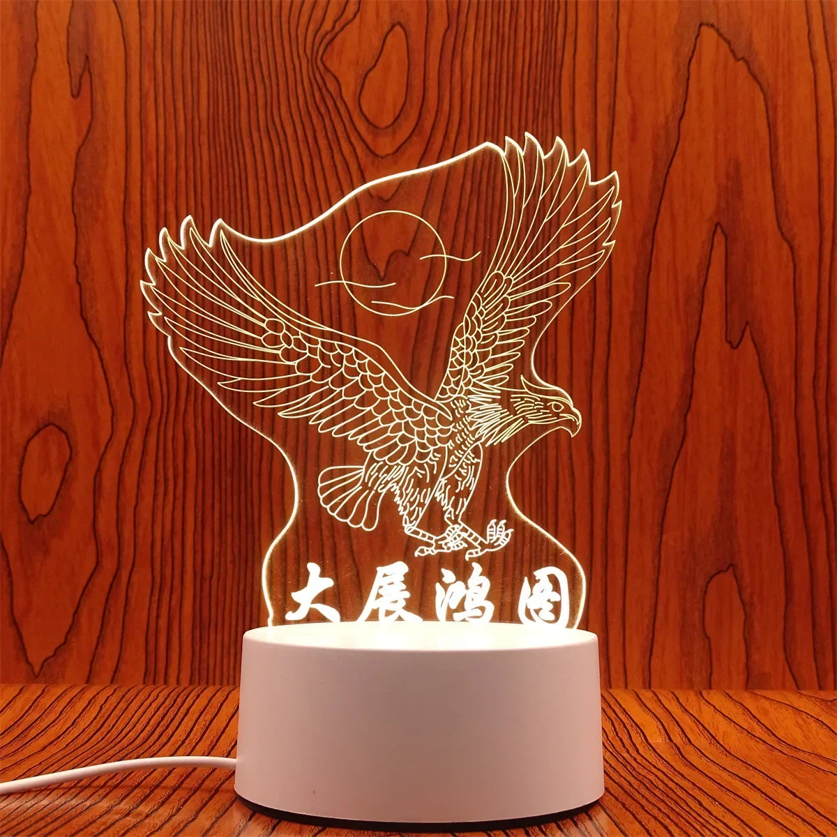 A white silhouette of an eagle with spread wings is illuminated by a light source, displayed on a wooden surface.