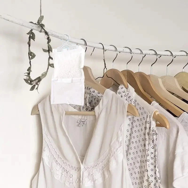 White reusable hanging moisture absorber bags on a wire rack with hooks