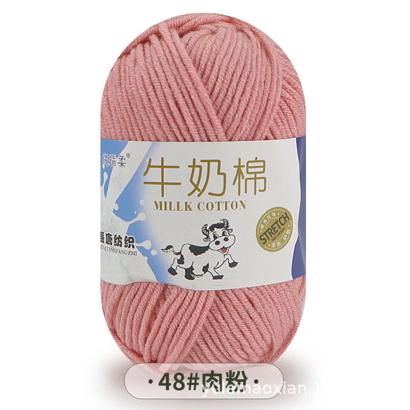 Pink milk cotton blend yarn skein with a label showing the product name and details