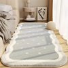 A plush gray decorative area rug with white polka dots and borders placed on a light wooden floor.