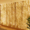 Golden sheer curtains illuminated by warm fairy lights creating a soft, glowing backdrop for home decor