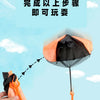 A hand is holding an orange parachute toy with a mini soldier, set against a light blue sky.