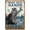 Vintage metal tin sign with text instructing to wash hands and featuring a raccoon illustration.