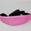Pink sleeping headrest for a baby car seat with a black belt strap