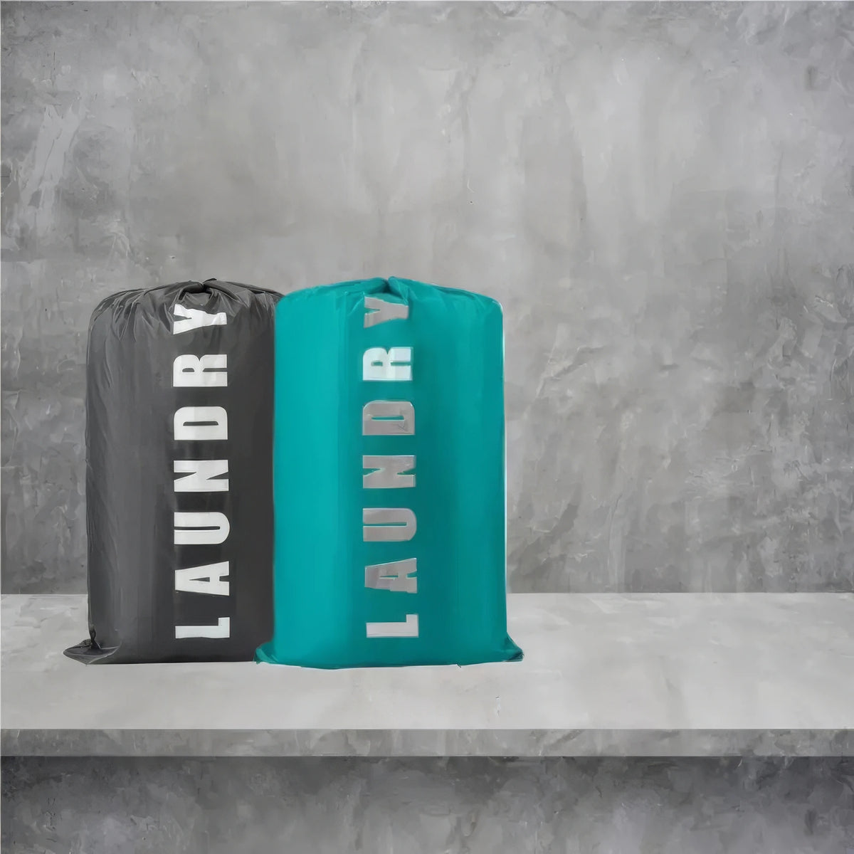 Two reusable laundry storage bags, one black and one teal, standing on a gray shelf.