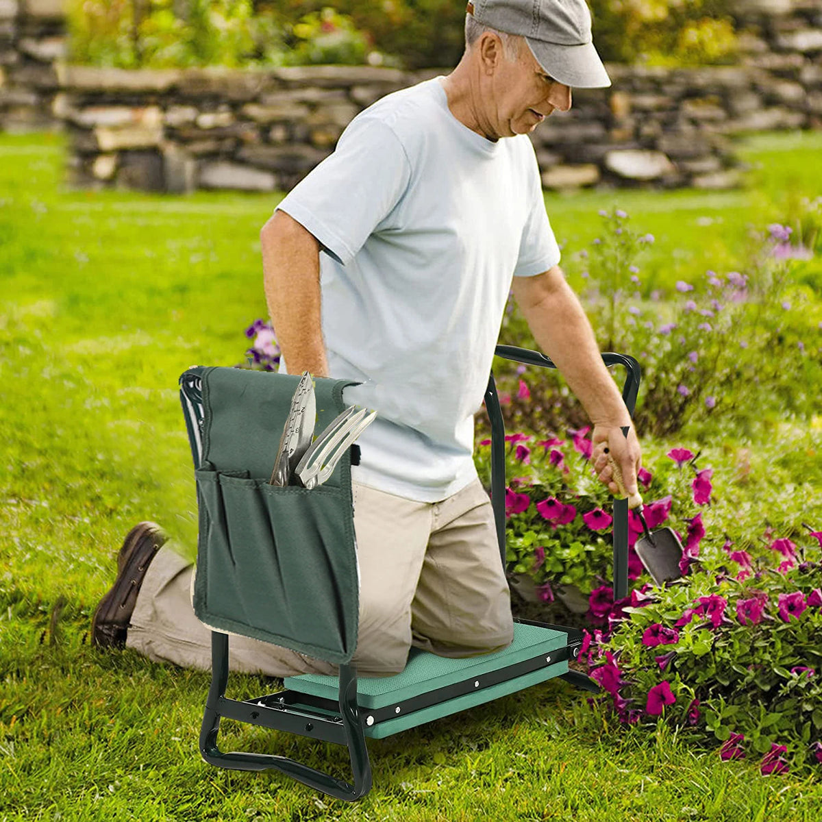 An elderly man kneeling on a heavy duty foldable garden kneeler seat with a tool pouch in a grassy garden.