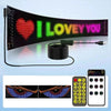 A flexible USB LED matrix display showing the text I LOVE YOU in bright green and purple lights.
