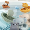 A collection of silicone animal finger puppets and bath toys floating in blue water.