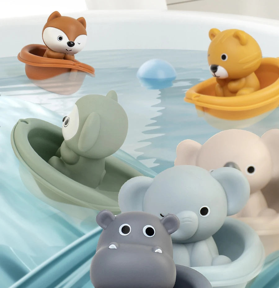 A collection of silicone animal finger puppets and bath toys floating in blue water.