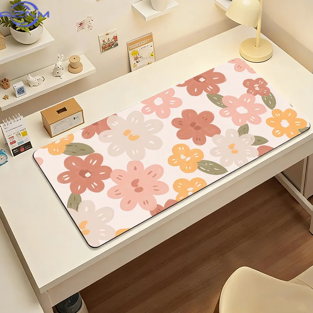 A pink and orange floral mouse pad is displayed on a white desk next to office supplies.