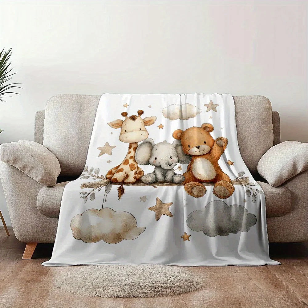 A white blanket featuring a print of a giraffe, an elephant, and a teddy bear on a light gray sofa.