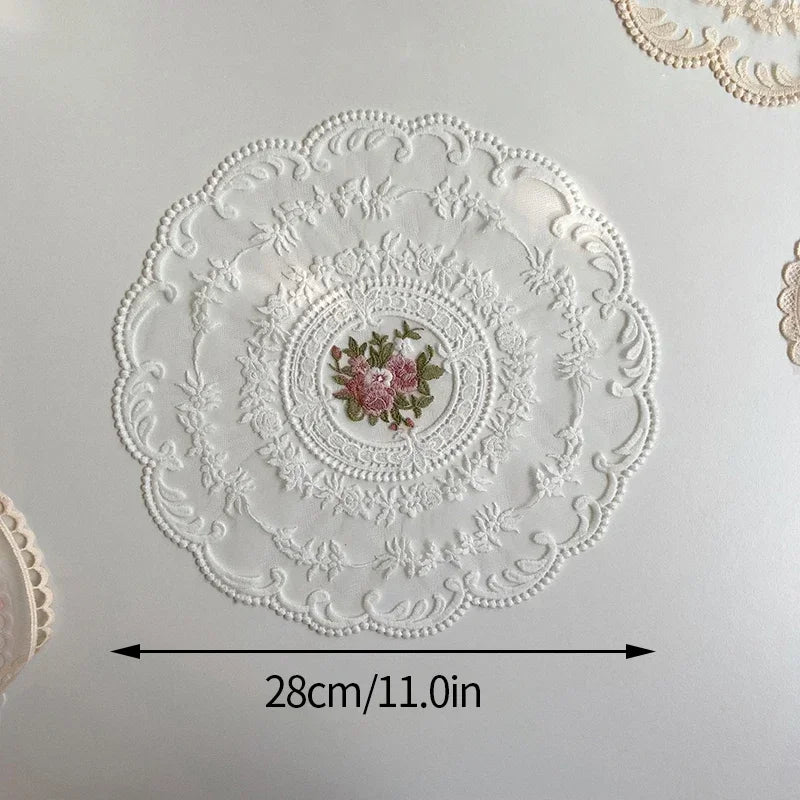 Elegant oval white lace embroidered placemat with a pink floral design