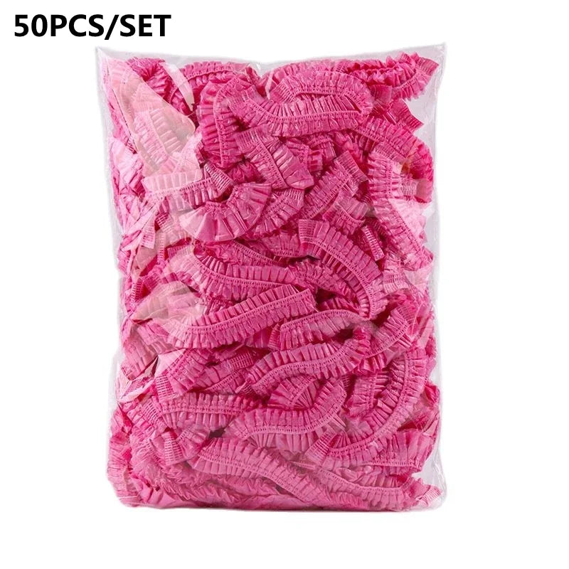 A bag of 50 pink disposable transparent waterproof shower caps