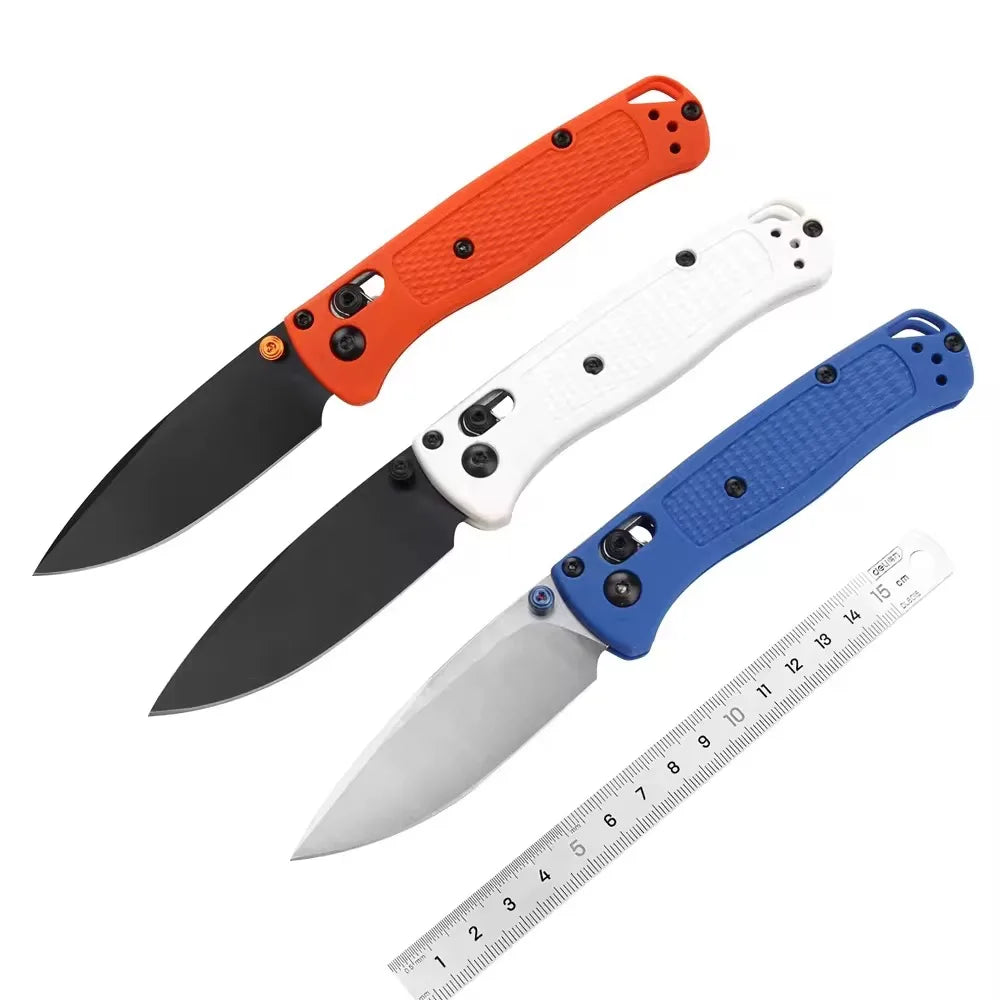 Orange and white compact folding knife with a stainless steel blade shown next to a ruler.