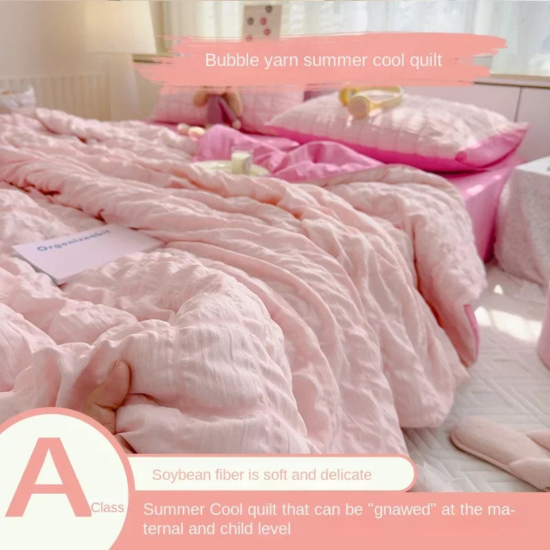 Pink bubble yarn summer cool quilt with a yellow headband and a label describing its suitability for maternal and child level