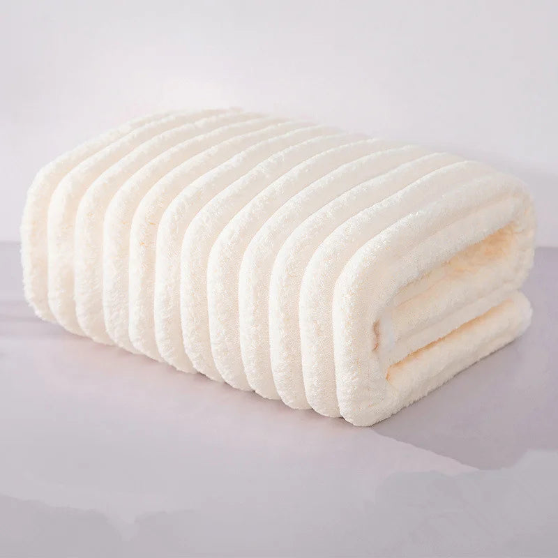 A rolled white microfiber towel with ridges is shown on a light surface.