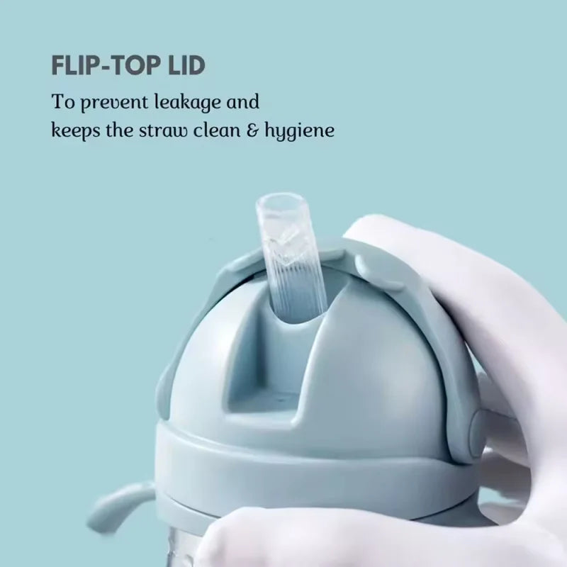 A hand is holding a light blue flip-top lid straw cup designed to prevent leakage and maintain hygiene.