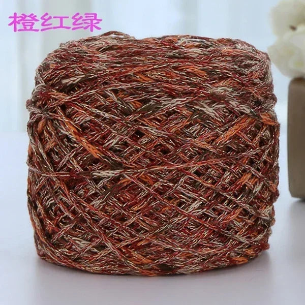 A ball of metallic silk crochet yarn with an orange and brown shimmer texture.