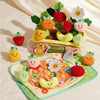 A collection of felt fruit and vegetable toys, including carrots, strawberries, and pumpkins, arranged in a display.