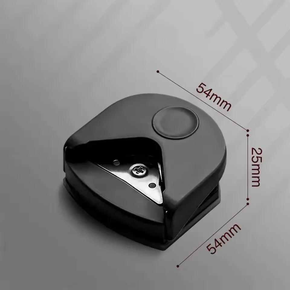 A black paper corner rounder cutter with dimensions marked on the side.