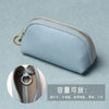A light blue PU leather key organizer wallet with a zipper shown against a muted background.