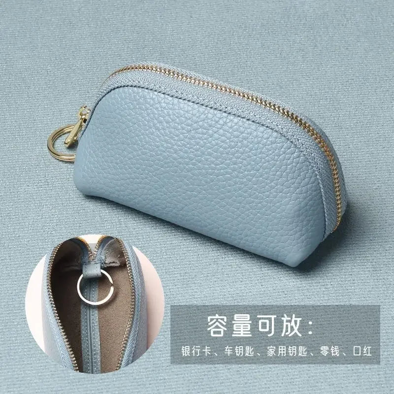 A light blue PU leather key organizer wallet with a zipper shown against a muted background.