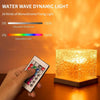 A hand adjusts the brightness and color of a water wave dynamic light projector illuminating a textured cube.